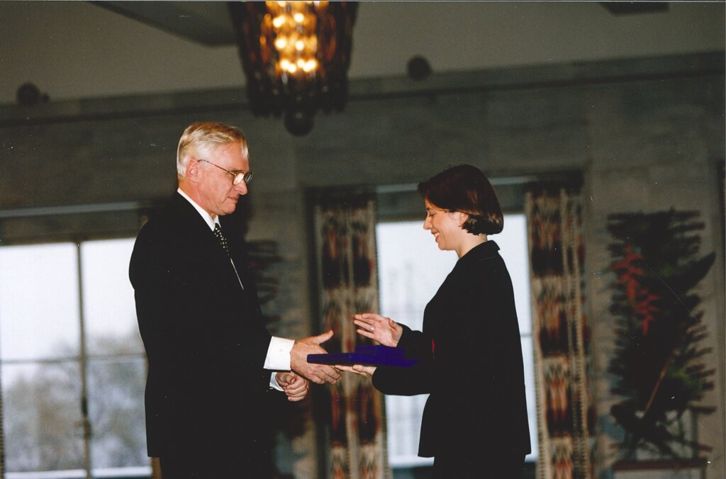 A woman accepting an award from a man