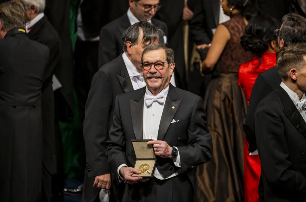 Physics laureate Alain Aspect showing his Nobel Prize medal