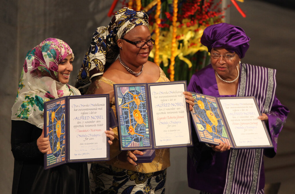 Three women showing their diplomas