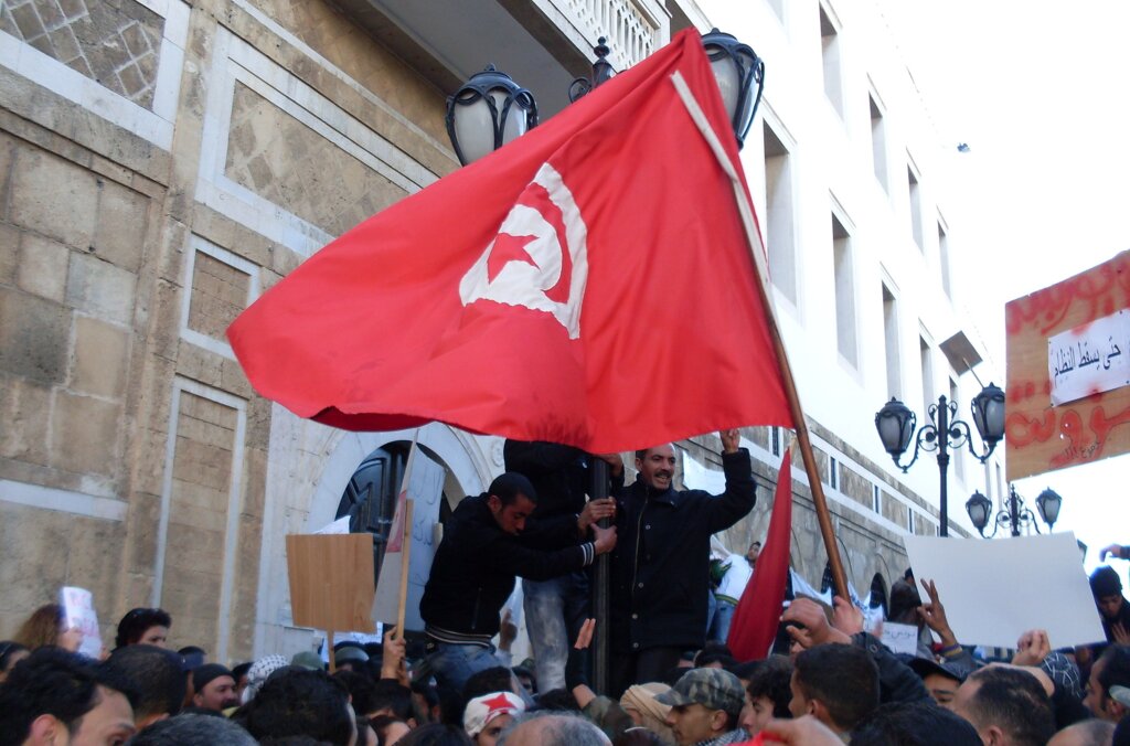 People in the streets holding a flag