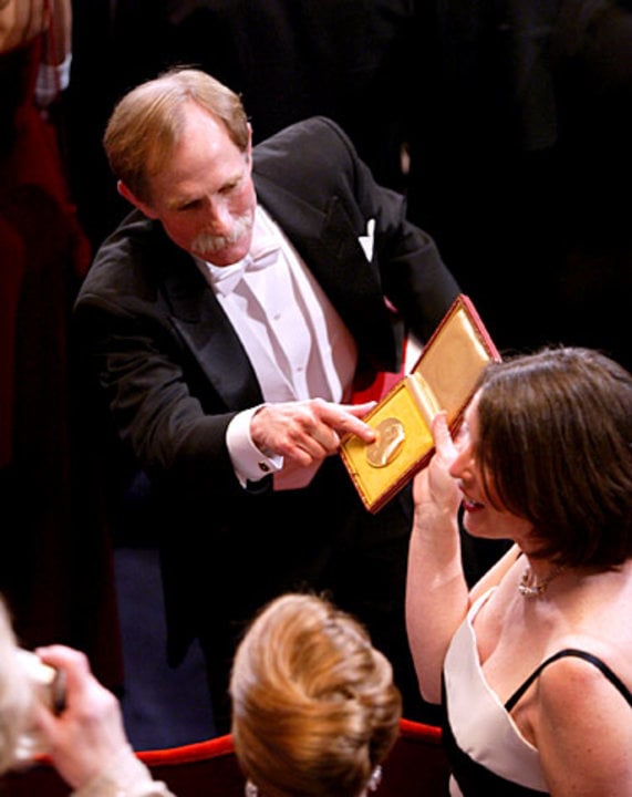Nobel Laureate in Chemistry Peter Agre shows his medal to his wife after the 2003 Nobel Prize Award Ceremony inside the Stockholm Concert Hall.