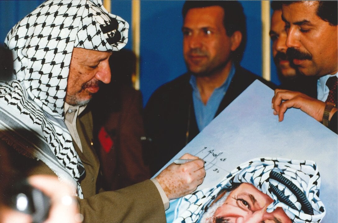 Yasser Arafat signing a portrait