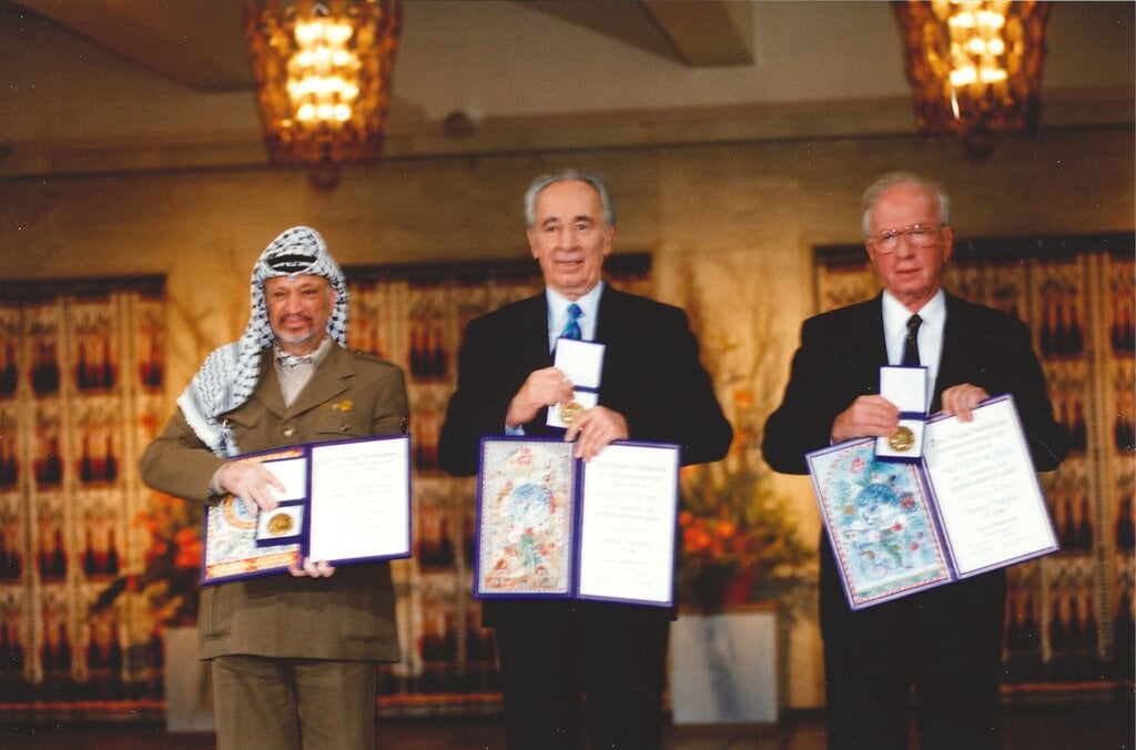 Yasser Arafat, Shimon Peres and Yitzhak Rabin showing their Nobel Prize medals and diplomas