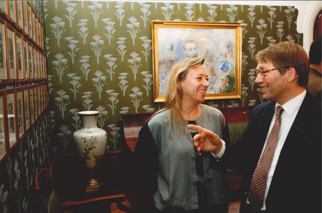 A woman and a man watching photos in a room