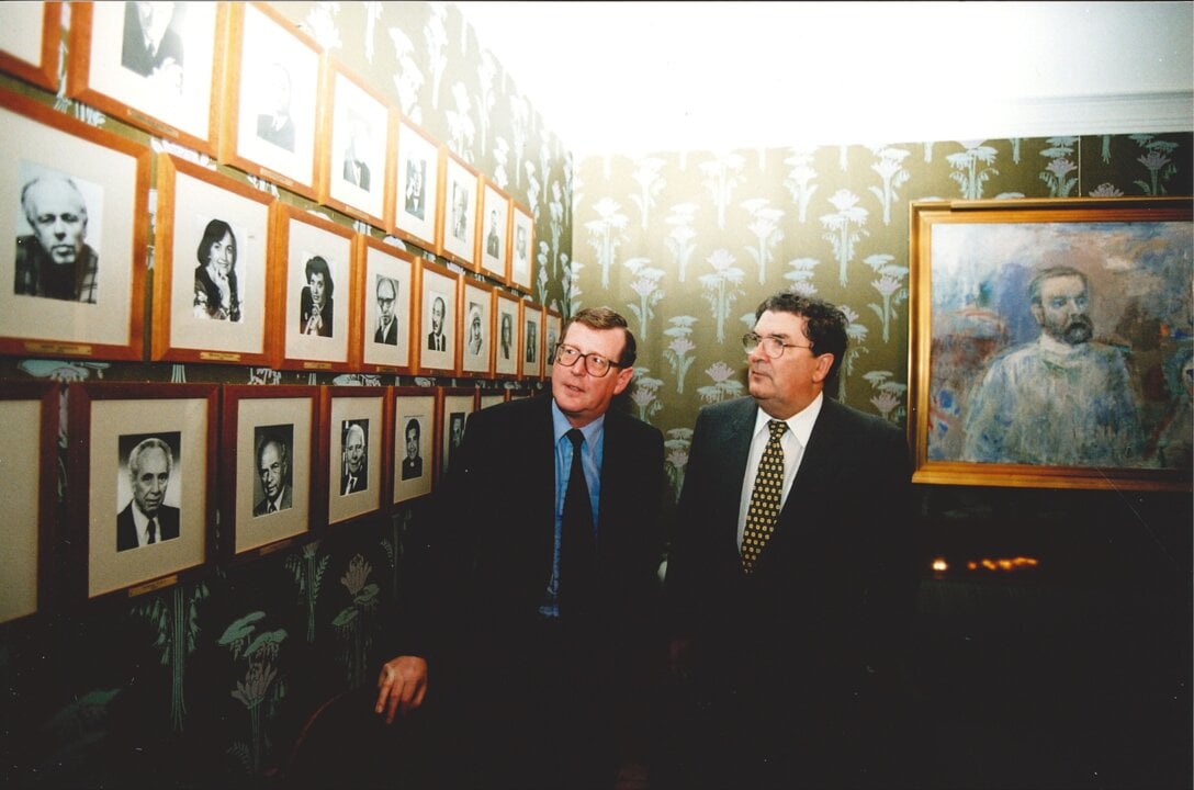 David Trimble and John Hume watching photos of previos peace laureates