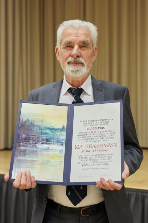 Klaus Hasselmann showing his Nobel Prize diploma.