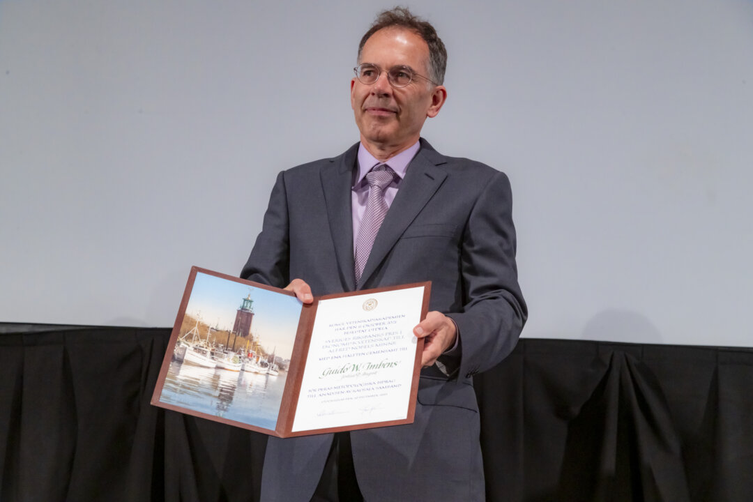Guido W. Imbens showing his diploma