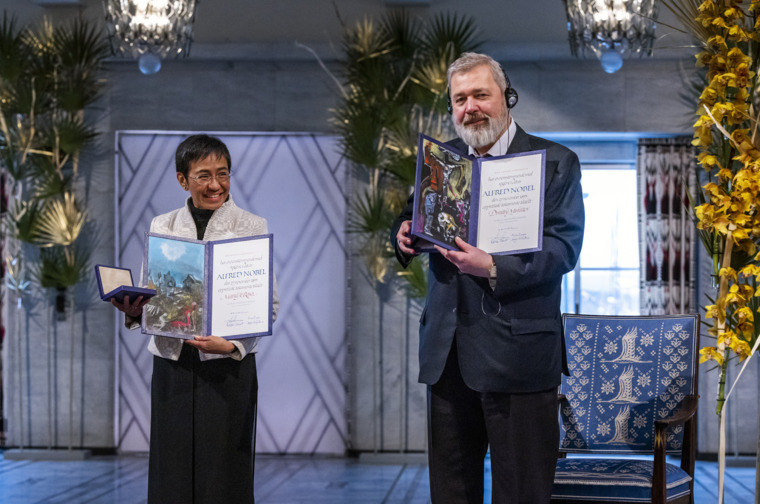 Peace laureates Maria Ressa and Dmitry Muratov showing their Nobel Prize diplomas