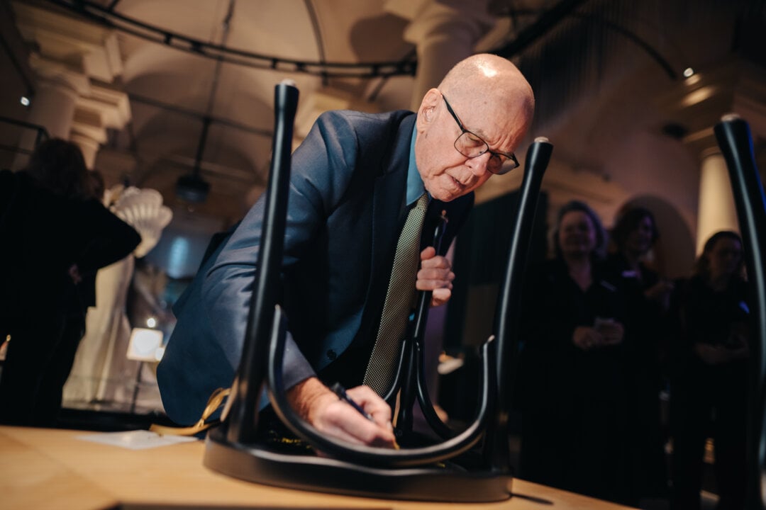 K. Barry Sharpless signs a chair at the Nobel Prize Museum
