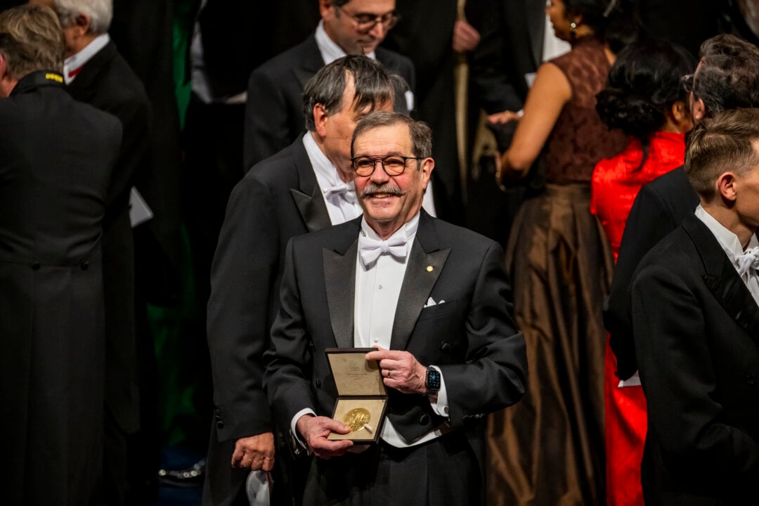 Physics laureate Alain Aspect showing his Nobel Prize medal