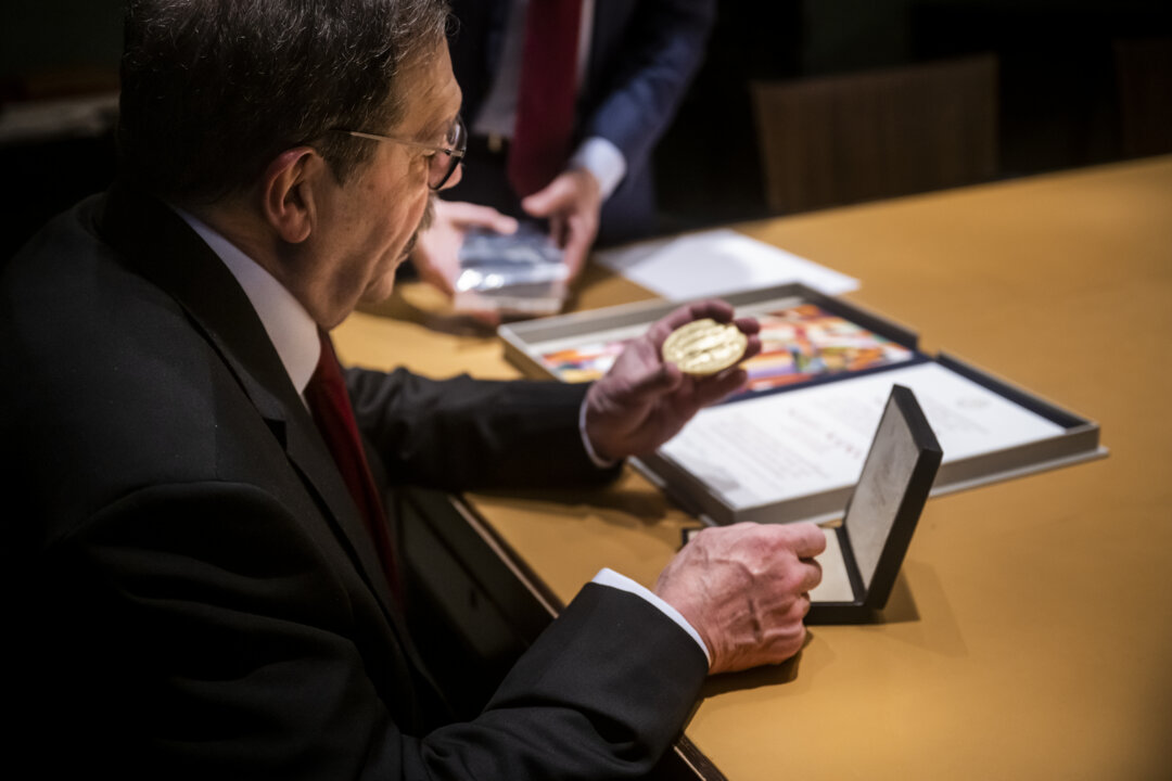 Physics laureate Alain Aspect looks at his Nobel Prize medal