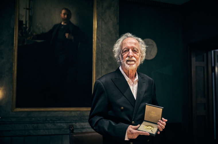 Pierre Agostini showing his Nobel Prize medal