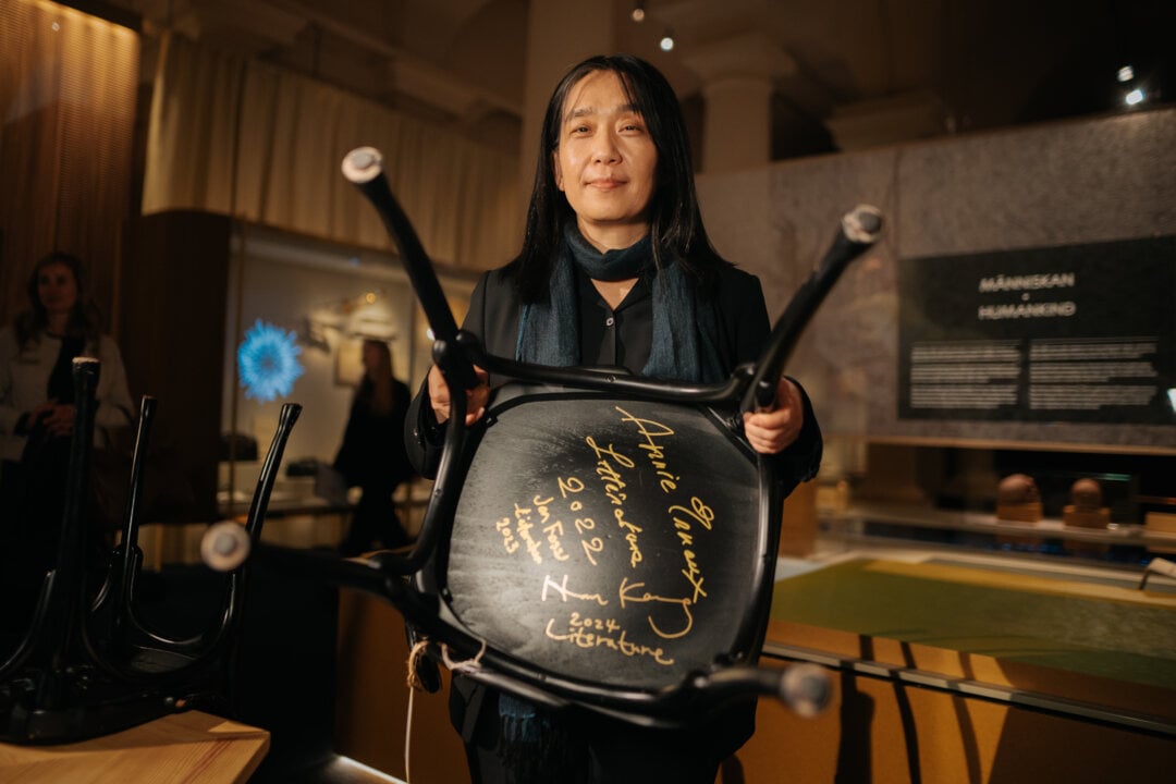 A woman showing a chair with her signature