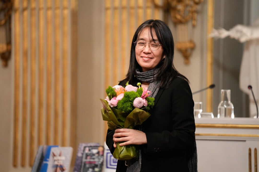 Awoman holding a bunch of flowers