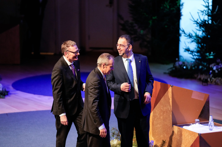 Three men on a stage