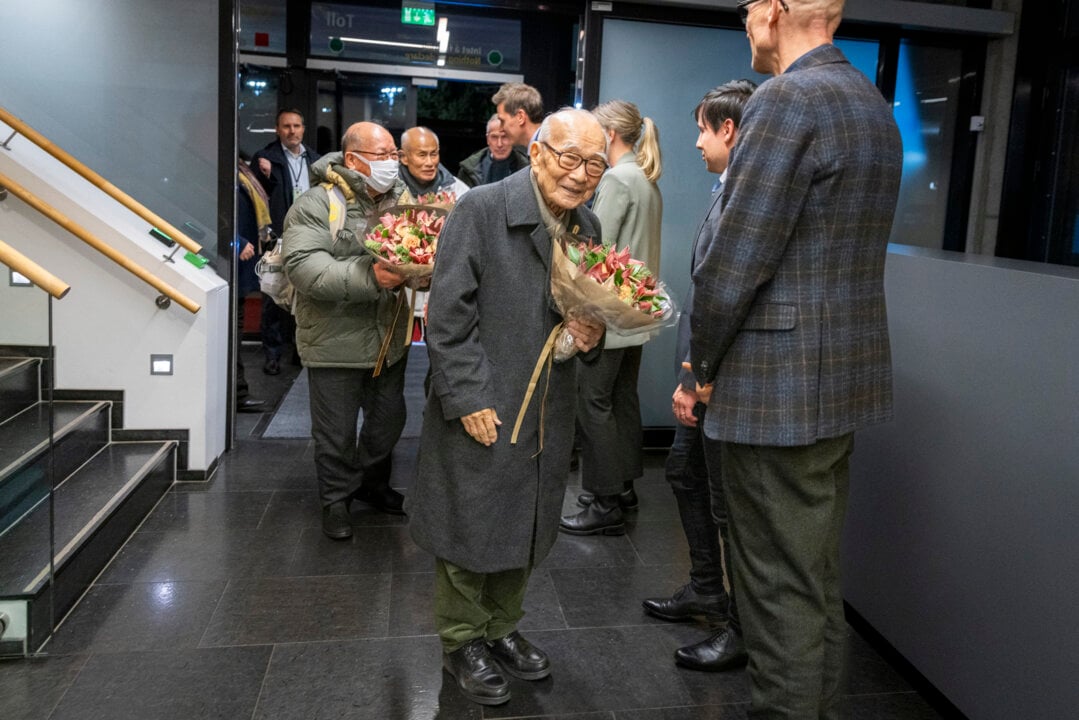 A man with a bunch of flowers arriving in an airport