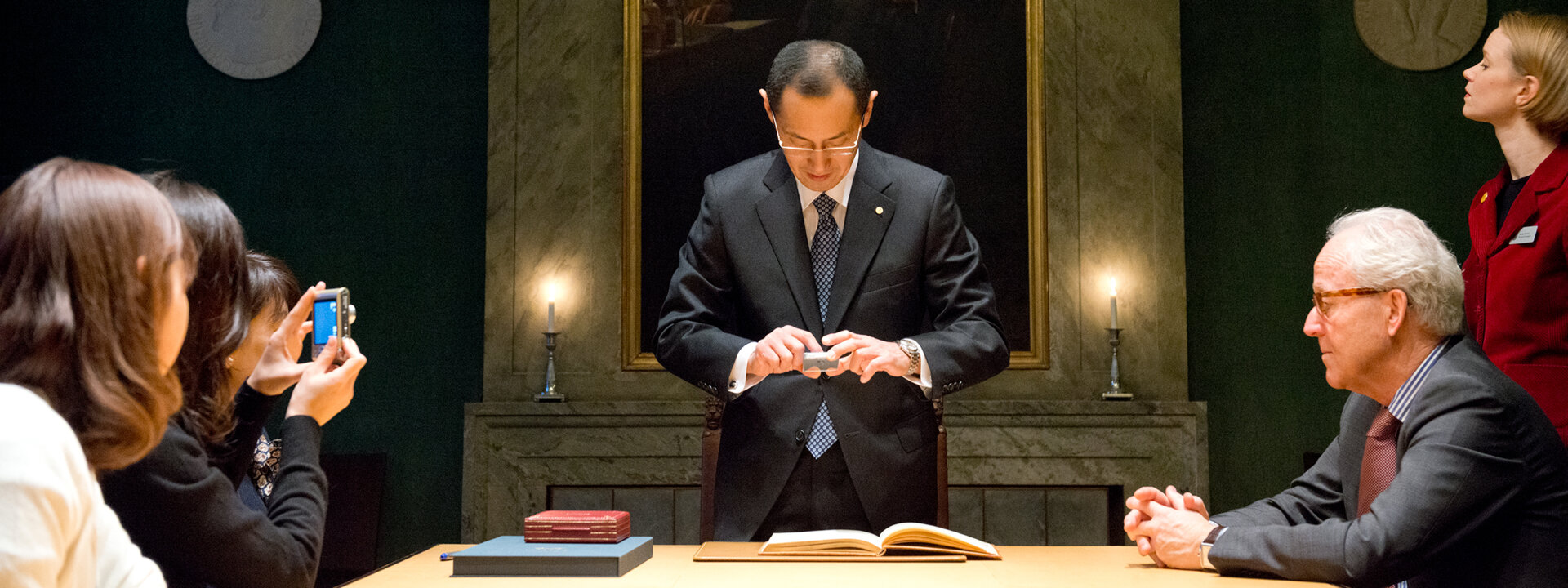 Shinya Yamanaka takes a photo of the Nobel Prize guest book