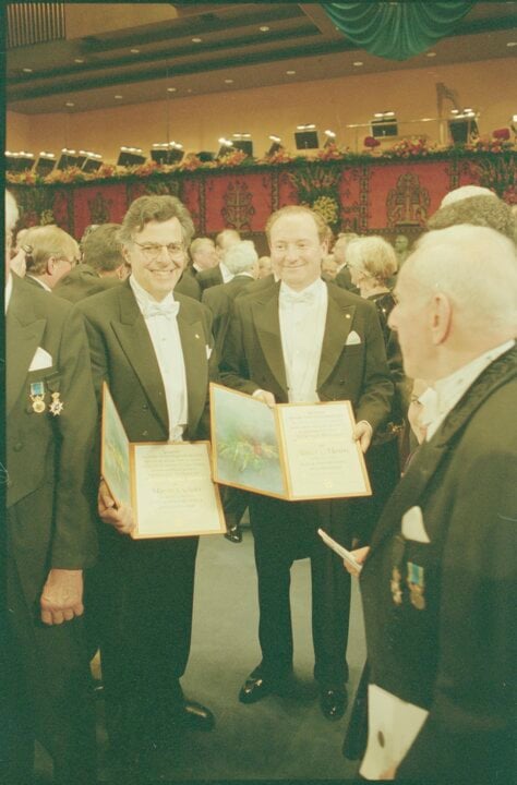 Myron S. Scholes and Robert C. Merton showing their diplomas