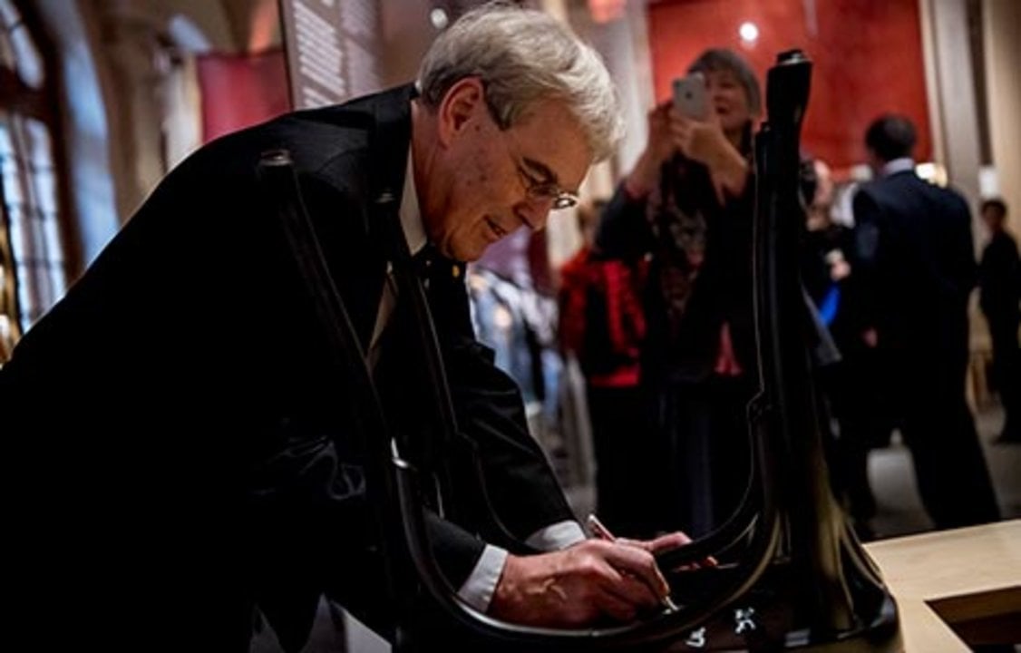 Richard Henderson autographs a chair at the Nobel Museum