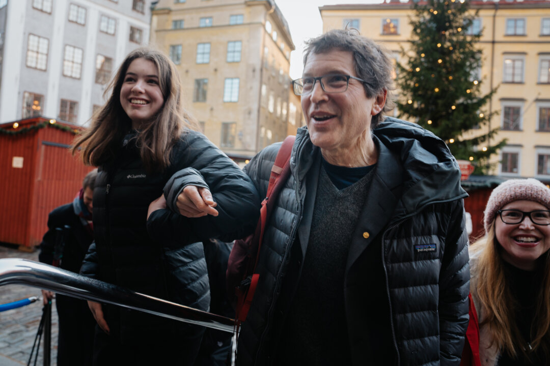 A man and a girl with a Christmas tree in the background