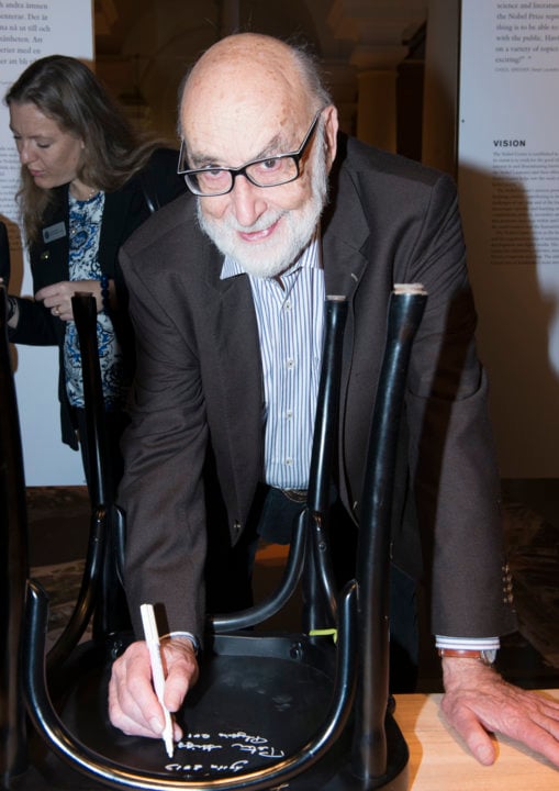 Like many Nobel Laureates before him, François Englert autographs a chair at Bistro Nobel at the Nobel Museum in Stockholm, 6 December 2013