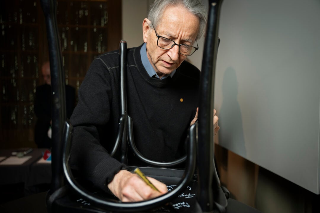 Geoffrey Hinton signing a chair