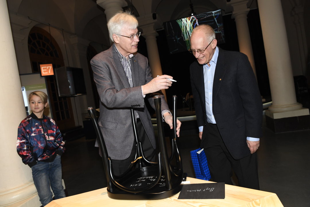 Bengt Holmström and Oliver Hart autograph a chair