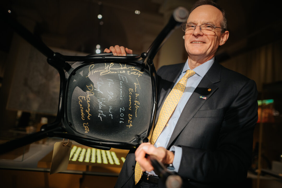 A man showing a signed chair