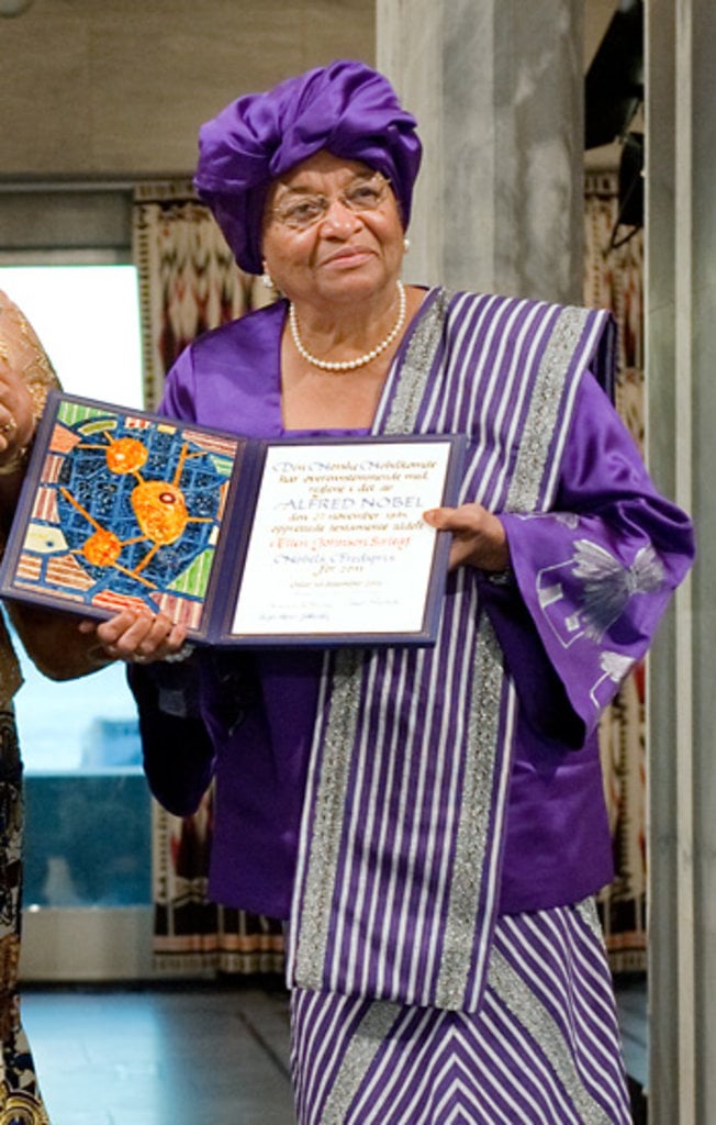 An African woman in a beautiful dress showing a diploma