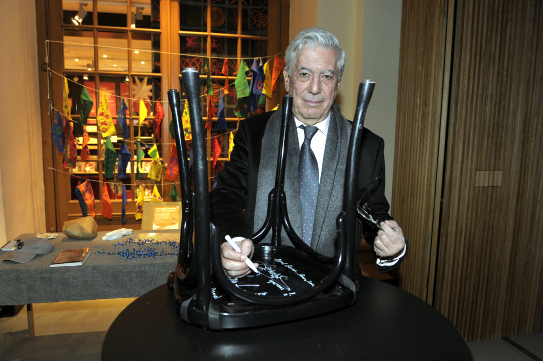 Mario Vargas Llosa autographs a chair