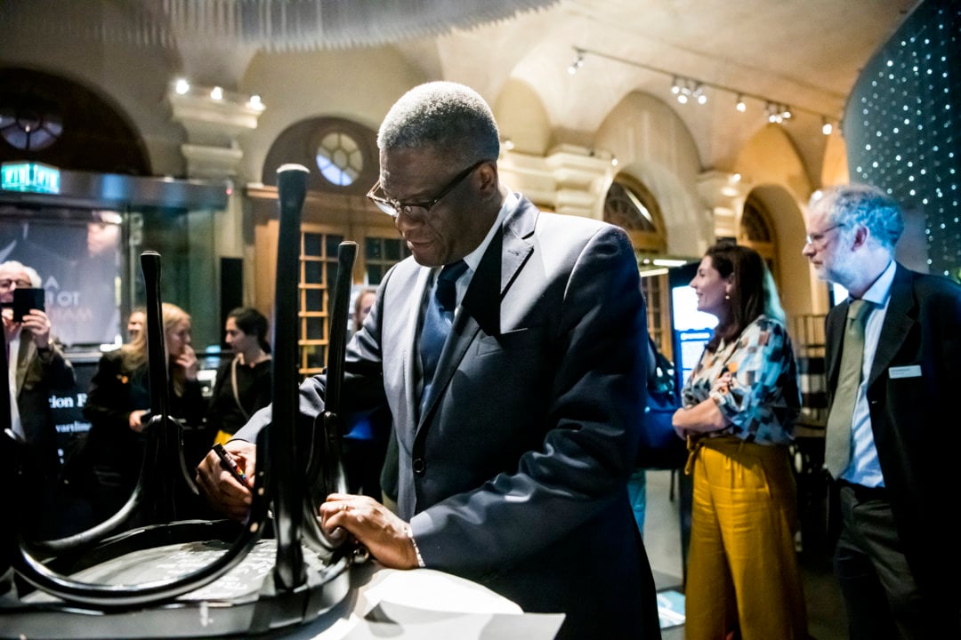 Denis Mukwege autographs a chair at the Nobel Prize Museum