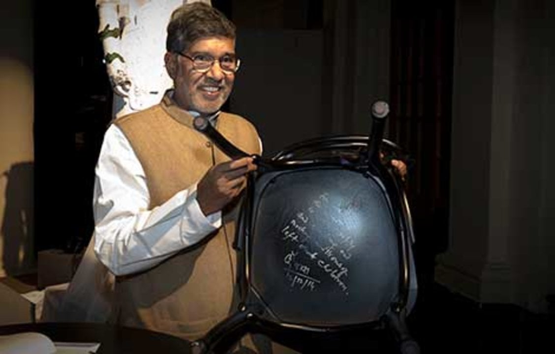 Like many Nobel Laureates before him, Kailash Satyarthi autographs a chair at Bistro Nobel at the Nobel Museum in Stockholm, 12 December 2014.