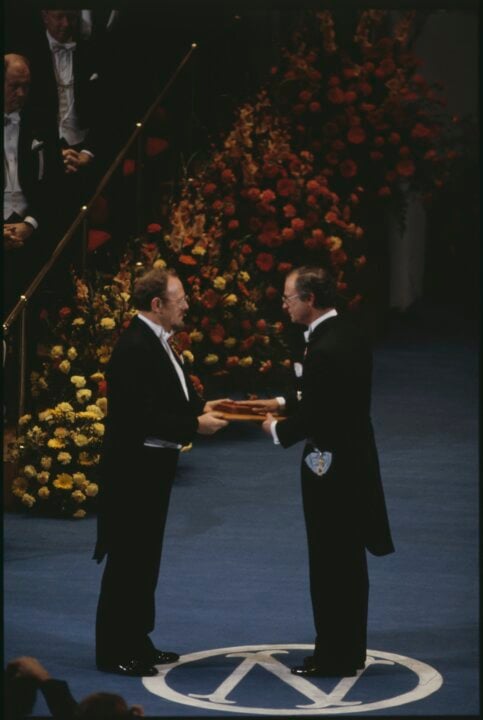 A man getting a medal from another man