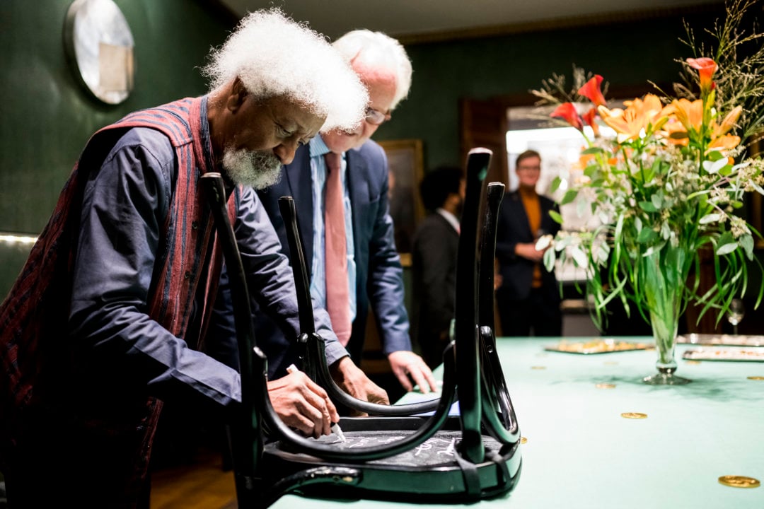 Wole Soyinka autographs a chair for the Nobel Prize Museum
