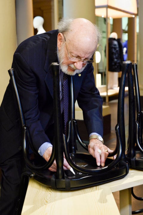 Like many Nobel Laureates before him, William C. Campbell autographs a chair at Bistro Nobel at the Nobel Museum in Stockholm.