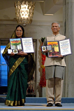 Mosammat Taslima Begum and Muhammad Yunus pose with their Nobel Peace Prize Medals and Diplomas