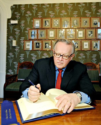 Martti Ahtisaari signs the guest book at the Norwegian Nobel Institute