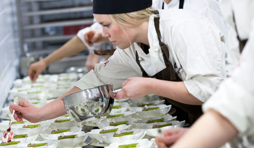 In the kitchen, the chefs prepare a three course dinner for 1,220 guests