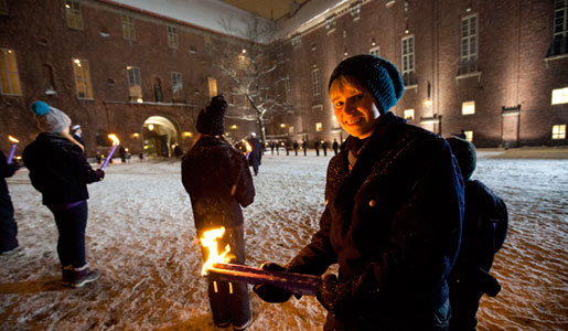 Scouters with torches outside the Stockholm City Hall