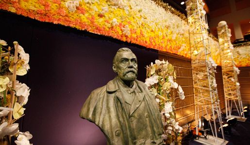 A bust of Alfred Nobel, surrounded by beautiful flowers