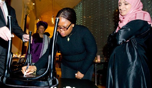 Leymah Gbowee autographs a chair at Bistro Nobel at the Nobel Museum in Stockholm