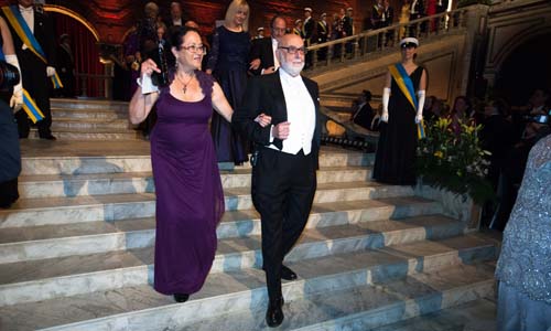François Englert proceeds into the Blue Hall with Mrs Rina Levitt, spouse of Chemistry Laureate Michael Levitt.