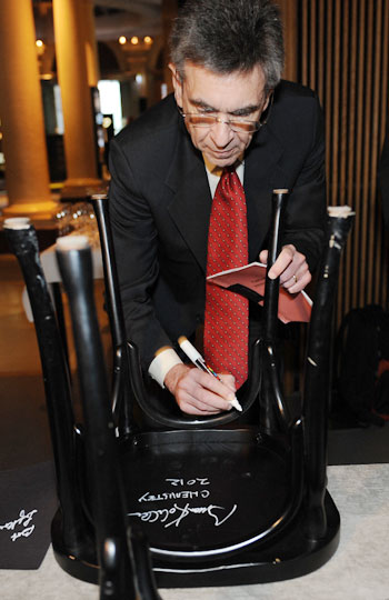 Like many Nobel Laureates before him, Robert J. Lefkowitz autographs a chair at Bistro Nobel at the Nobel Museum in Stockholm