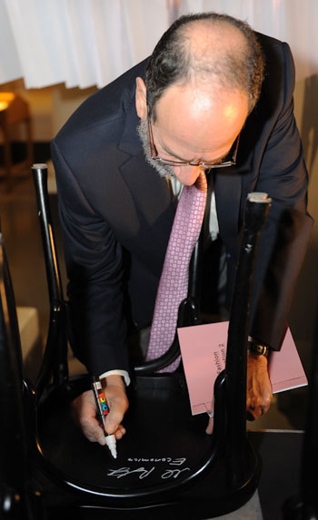 Like many Laureates before him, Alvin E. Roth autographs a chair at Bistro Nobel at the Nobel Museum in Stockholm